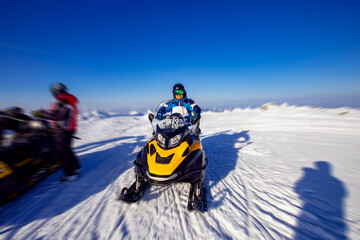 Fototapeta na wymiar Concept winter sports tour. Snowmobile races in snow