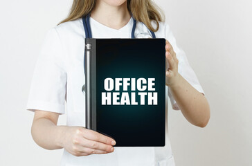 Fototapeta na wymiar The doctor is holding a tablet with the inscription - Office Health
