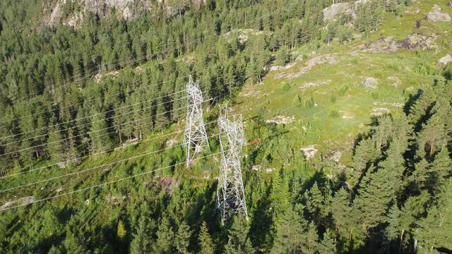Approaching massive high voltage power lines in Norwegian mountain - Distribution and export of electricity from renewable energy sources - Aerial from far to closeup