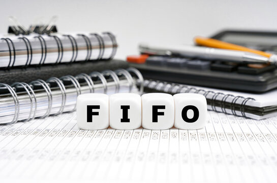 On the table, among office objects, cubes with the inscription - FIFO