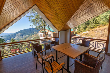 Wooden tourist lodge sitting area with view of scenic Himalaya mountain landscape at Narkanda Himachal Pradesh, India