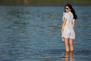 young woman in the water in a dress