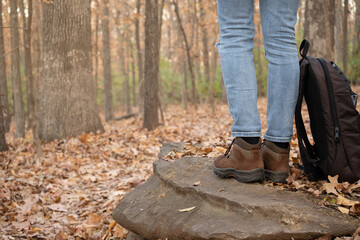 Close-up of woman's legs in hiking boots in the forest