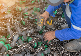 Mechanic removing nut from roller to replace conveyor chain.