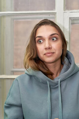 Facial portrait of a young beautiful girl in a sweatshirt with a hood