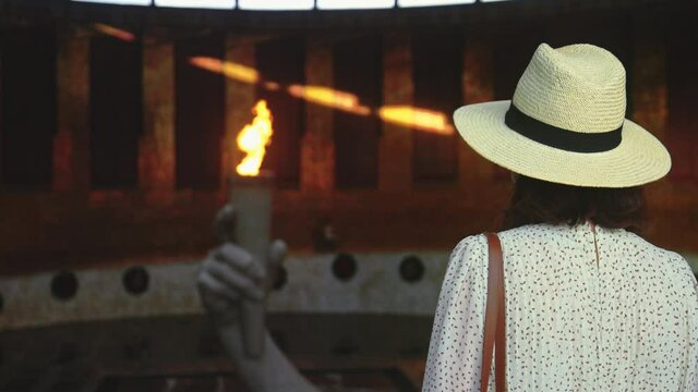 A young girl in a hat looking at the eternal flame in the pantheon