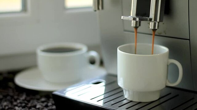 hot coffee pouring from coffee making machine into a cup stock video