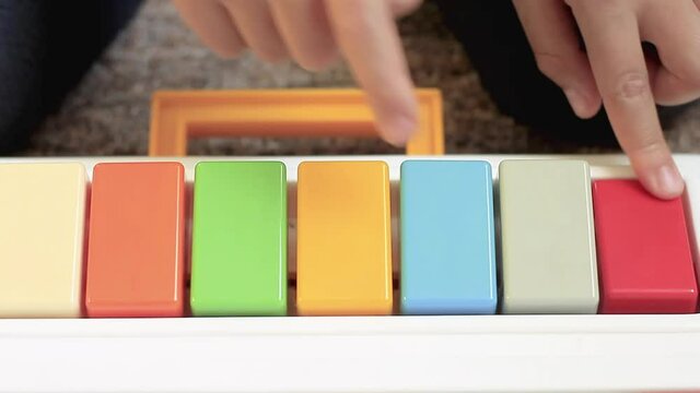 child playing toy piano with colours of the rainbow at home stock video