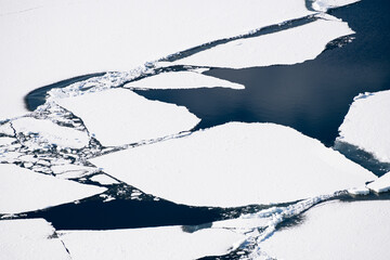 Ice floes on the lake. Aerial drone view. Abstract nature background. Baikal lake, Siberia, Russia.