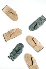 Aesthetic grey and beige craft warm winter felt mittens on white background. DIY concept. Flat lay, top view fashion pattern