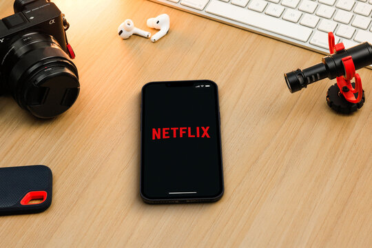 Netflix app on smartphone iPhone 13 Pro screen on wooden table. Content creator environment with keyboard, camera and mic. Rio de Janeiro, RJ, Brazil. November 2021