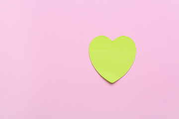 Sticky notes in shape of heart on pink background