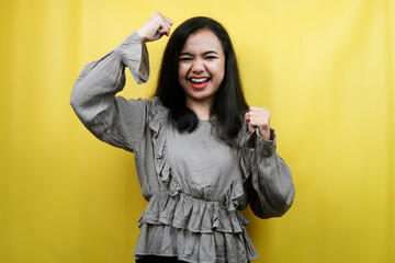 Beautiful young woman with clenched fists, success, good work, victory, cheerful and confident, isolated