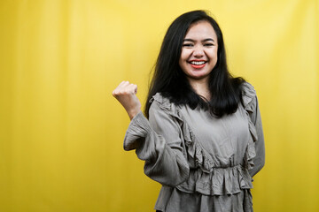 Beautiful young woman with clenched fists, success, good work, victory, cheerful and confident, isolated