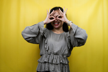 Beautiful young woman with glasses sign hands, peeking at something, binoculars hands, isolated