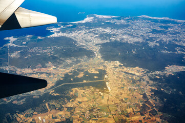 Wing of an airplane flying above the land