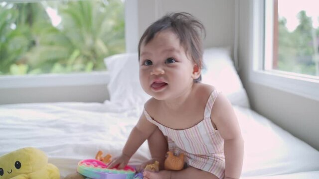 asian baby infant playing on bed and sneezing then smile. laughing  happy kid sneeze. playing and smile at home on bed.