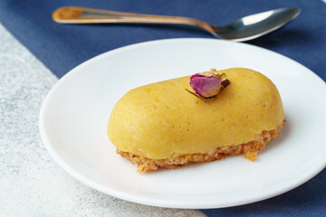 Mini mousse pastry dessert with rose on white plate