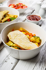 Close-up Baked turkey breast fillet and Italian pasta salad. Traditional Italian salad with tomatoes and mozzarella caprese. Food composition on a rustic background. Mediterranean Kitchen recipes