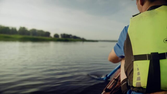 A young man is kayaking on the river against a beautiful landscape. Travel. Tourism.