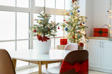 Small Christmas tree on dining table in light kitchen