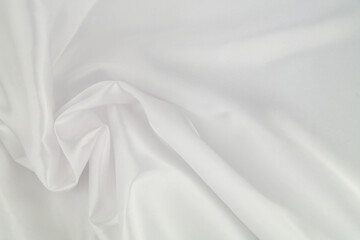 Fototapeta na wymiar White satin or silk fabric as background. Elegant wallpaper, wedding backdrop or design element. 