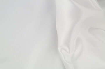 White satin or silk fabric as background. Elegant wallpaper, wedding backdrop or design element.	