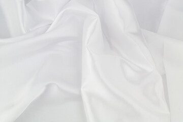 White satin or silk fabric as background. Elegant wallpaper, wedding backdrop or design element.	