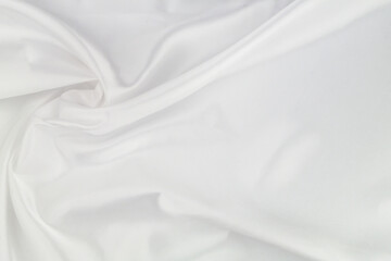 Obraz na płótnie Canvas White satin or silk fabric as background. Elegant wallpaper, wedding backdrop or holidays design element. 