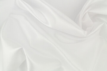 Fototapeta premium White satin or silk fabric as background. Elegant wallpaper, wedding backdrop or design element. 
