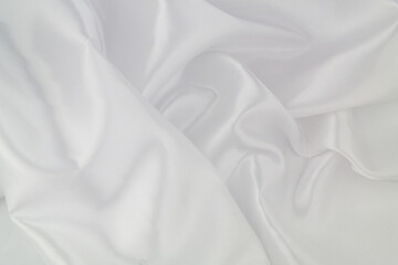 White satin or silk fabric as background. Elegant wallpaper, wedding backdrop or design element.	