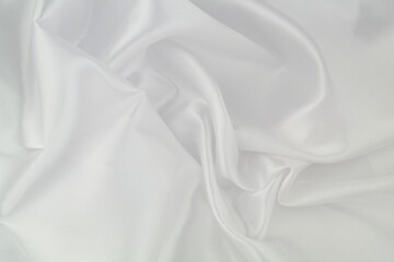 White satin or silk fabric as background. Elegant wallpaper, wedding backdrop or design element.	