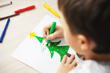 Child draw christmas tree. Christmas holidays. Boy write a letter to Santa