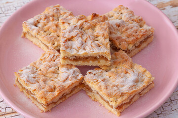 Five apple cake slices with razed dough, one on top of the others four, view from above