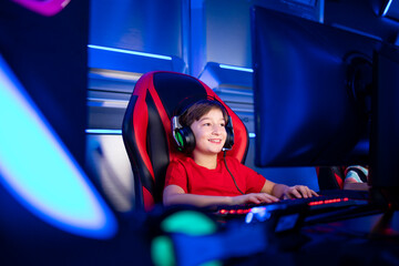 Professional young gamer boy with headphones playing computer video game and streaming.