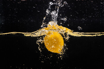 Image of Fresh yellow lemon falling into the water with a splash of water and air bubbles, isolated on a black background.
 printed on Printed Glass Splashbacks