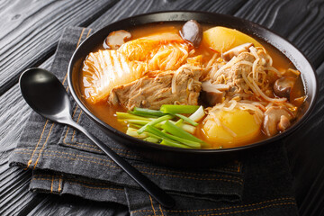 Gamjatang Spicy Pork Neck and Potato Stew close up in the bowl on the table. Horizontal
