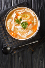 Canja de galinha is a popular chicken soup of Portuguese, Cape Verdean, and Brazilian cuisine close up in the plate on the table. Vertical top view from above