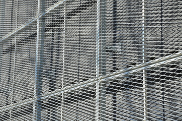 steel cladding of a building with a expanded metal lattice structure. galvanized gray nets protect...