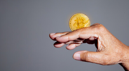 The elderly's hand is holding a Bitcoin gold coin. The cryptocurrency money Financial confidence of the elderly after retirement concept.