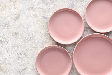 Stylish pink plates on light grunge background