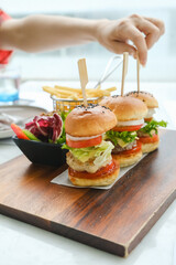 mini three burgers served with french fries