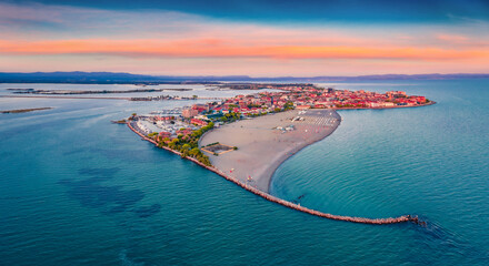 Beautiful summer scenery. Breathtaking summer view  from flying drone of public beach of Grado port, small town located between Venice and Trieste. Magnificent evening seascape of Adriatic sea. - obrazy, fototapety, plakaty
