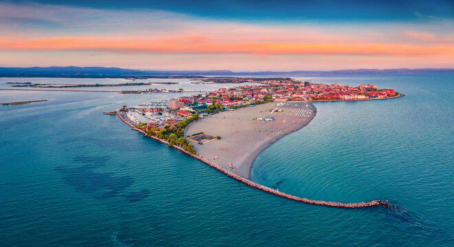 Beautiful summer scenery. Breathtaking summer view  from flying drone of public beach of Grado port, small town located between Venice and Trieste. Magnificent evening seascape of Adriatic sea.
