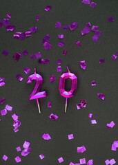 20, silver candles on dark background with glitters. Festive colorful background.