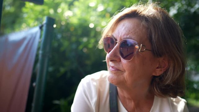 older woman wearing big sunglasses outside