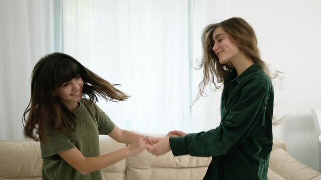 Young Mother And Daughter Dancing At Home, Having Fun Together, Slow Motion