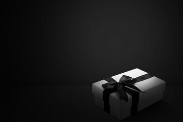 White gift box with a black ribbon with a black background