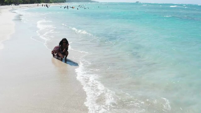 Bikini model drawing on sand at Maimon Dominican Republic