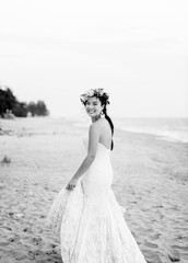 Fototapeta na wymiar Young bride in her wedding dress on the beach